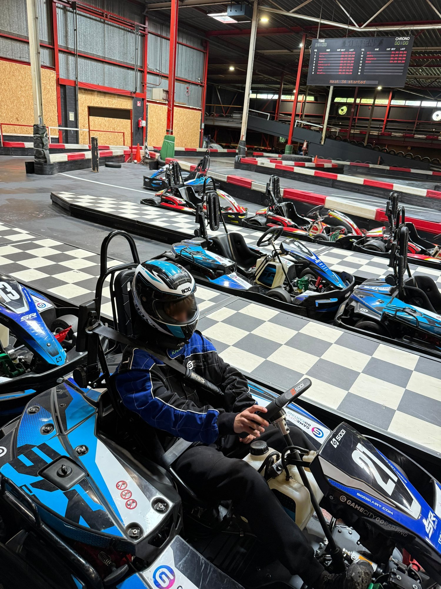 Een jongere van Cara Care met helm in een kart op de baan
