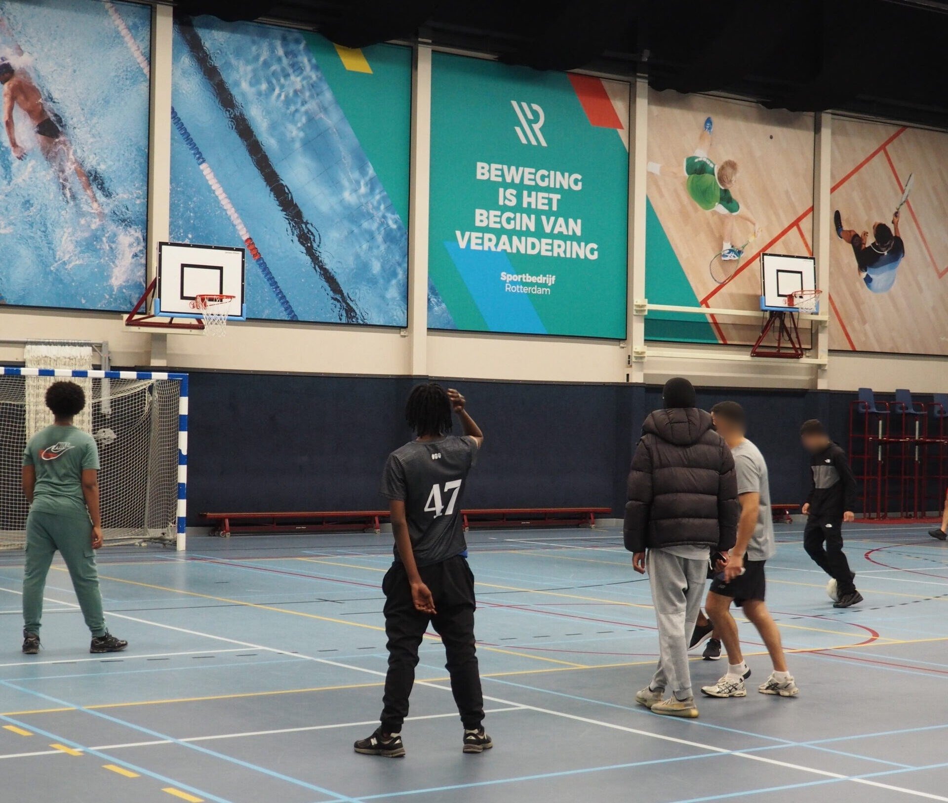 Jongeren van Cara Care spelen zaalvoetbal onder de muurtekst ‘Beweging is het begin van verandering’